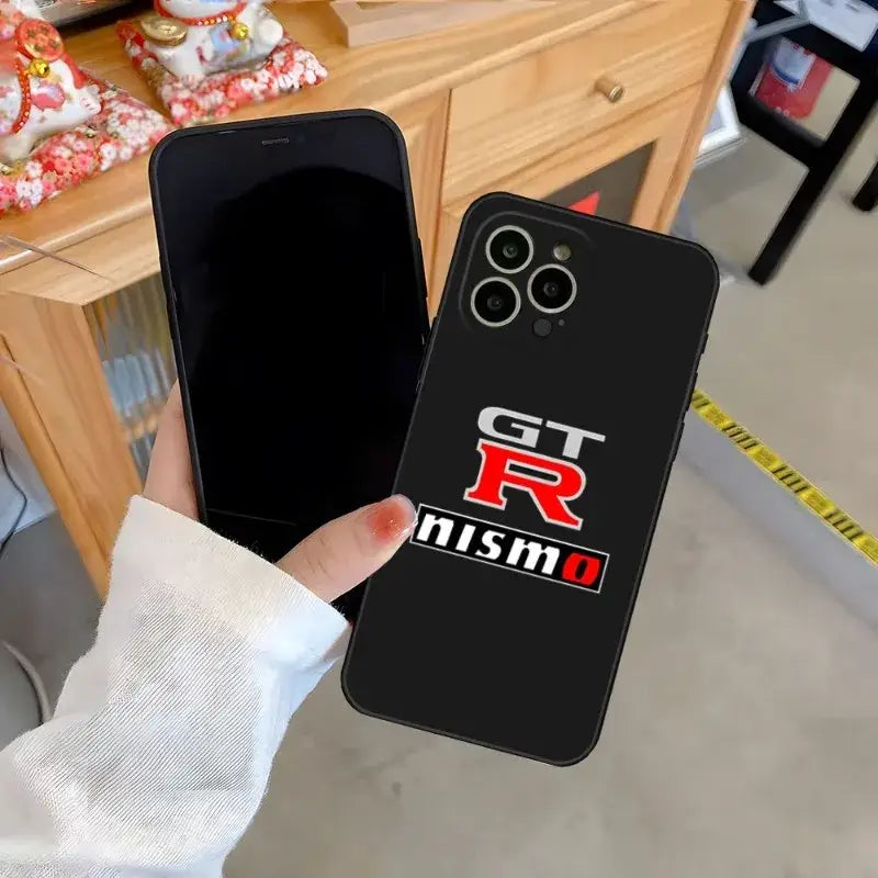 a person holding a phone case with the logo of a car