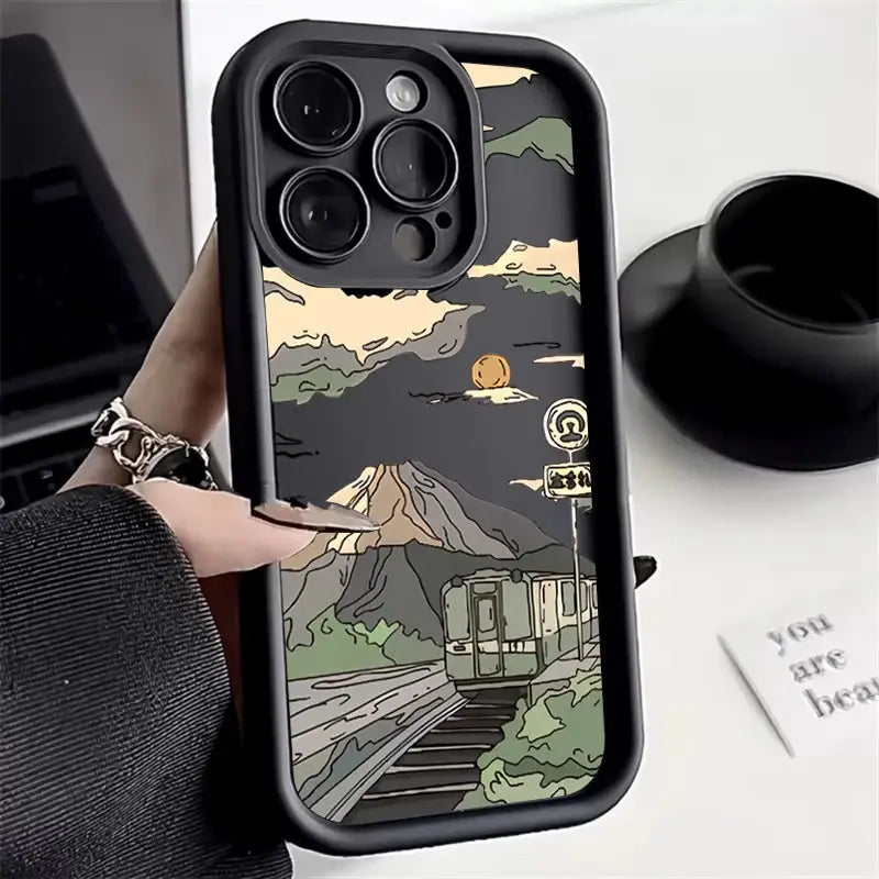 a person holding a phone case with a mountain scene