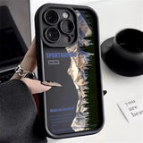 a person holding a phone case with a mountain scene