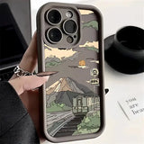 a person holding a phone case with a mountain scene