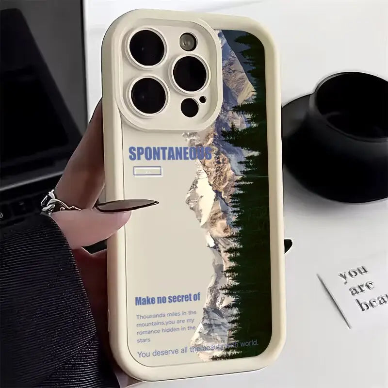 a person holding a phone case with a mountain scene