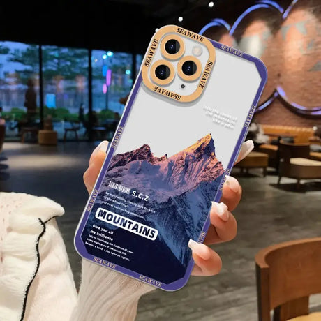 A person holding a phone case with a mountain scene