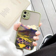 A person holding a phone case with a painting on it