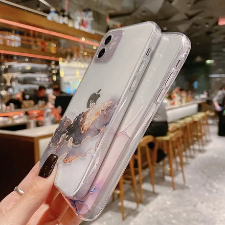 A person holding a phone case with a painting on it