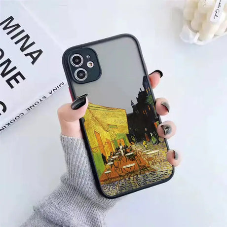 A person holding a phone case with a painting on it