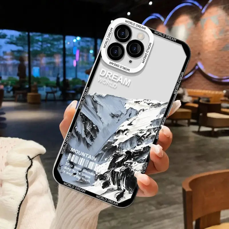 A person holding a phone case with a photo of a mountain