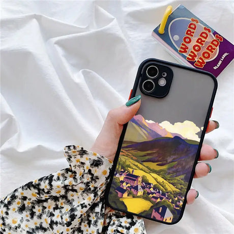 A person holding a phone case with a picture of a mountain