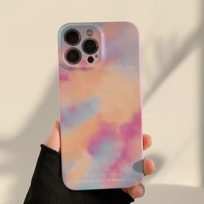 a person holding a phone case with a pink and blue cloud pattern