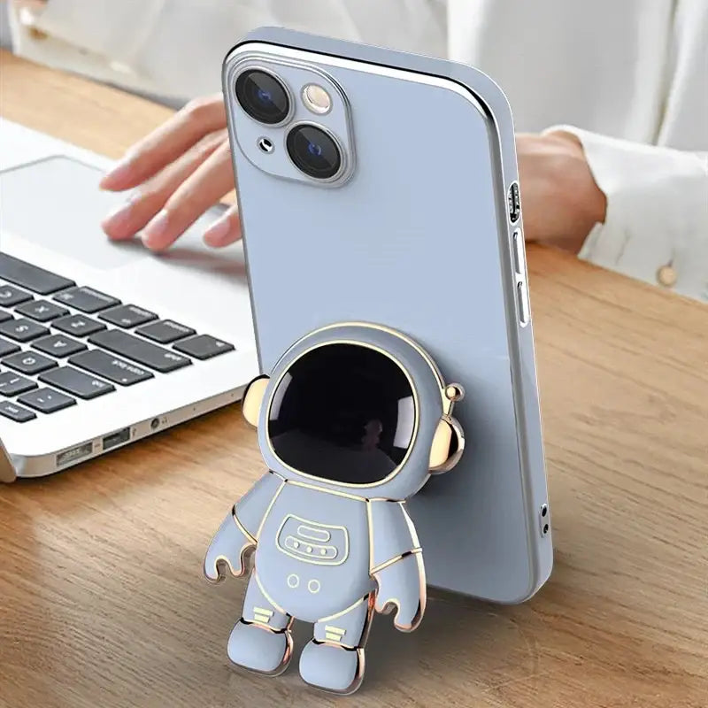 a person holding a phone case with a small astronaut