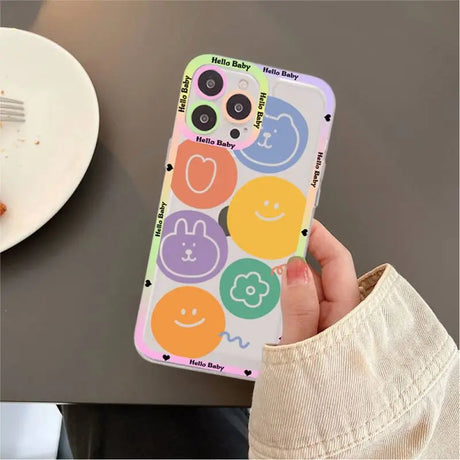 A person holding a phone case with smiley faces on it