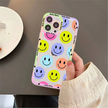 A person holding a phone case with smiley faces on it