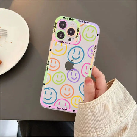 A person holding a phone case with smiley faces on it