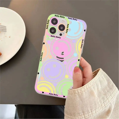 A person holding a phone case with a smiley face on it