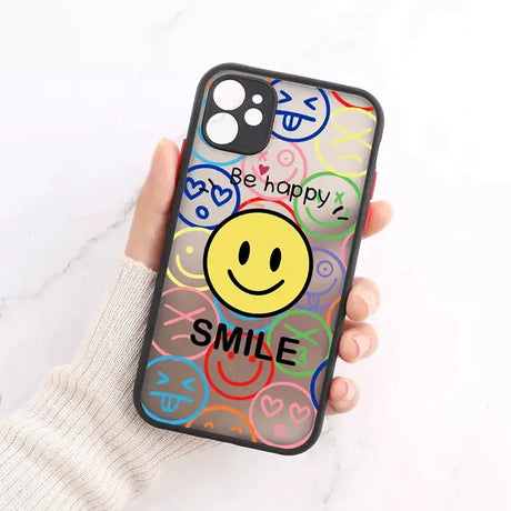 A person holding a phone case with a smiley face