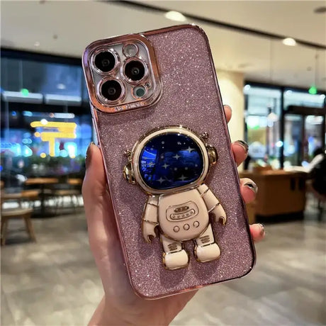 A person holding a phone case with a spaceman on it