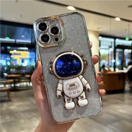 A person holding a phone case with a spaceman on it