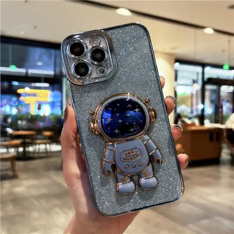 A person holding a phone case with a spaceman on it