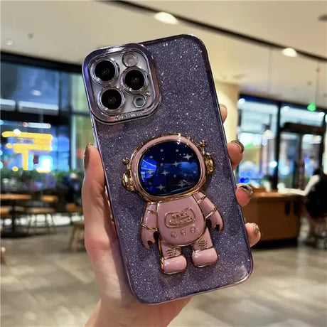 A person holding a phone case with a spaceman on it