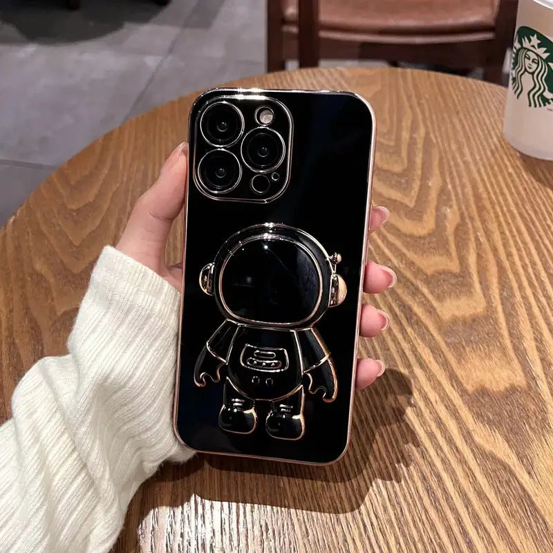 a person holding a phone case with a starbucks cup in the background