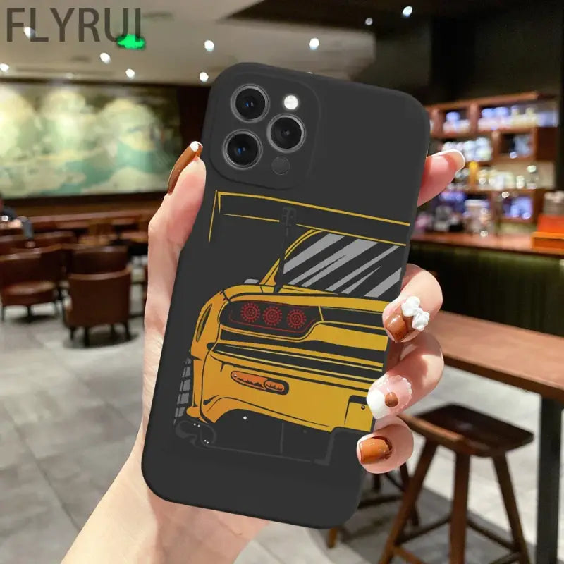 a person holding up a phone case with a yellow car