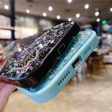 A person holding a phone with a glitter case