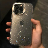 a person holding a phone with glitter on it