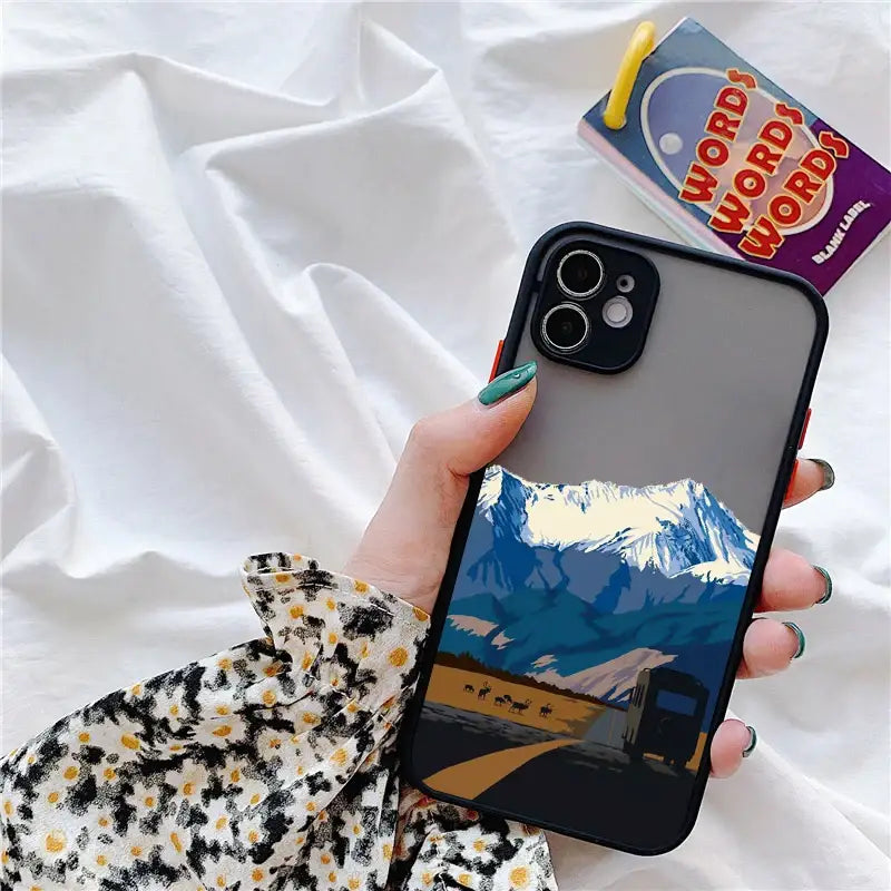 a person holding a phone with a picture of mountains on it
