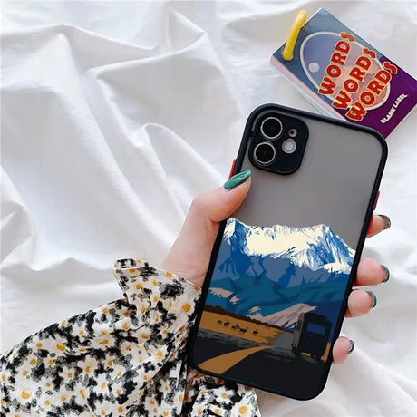 A person holding a phone with a picture of mountains on it