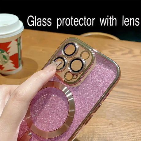 A person holding a phone with a pink glitter case