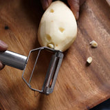 a person cutting a piece of onion on a wooden cutting board