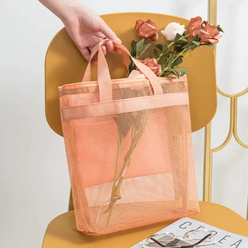 a person holding a pink mesh bag with flowers