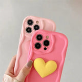 a person holding a pink phone case with a heart