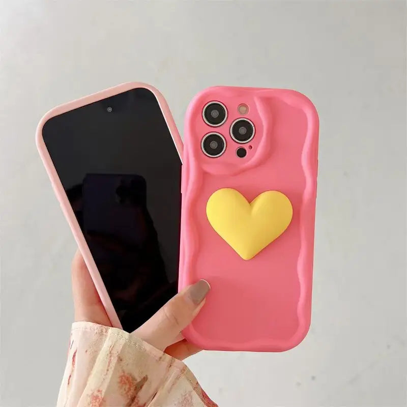 a person holding a pink phone case with a heart on it