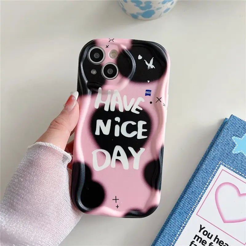 a person holding a pink phone case with the words have nice day