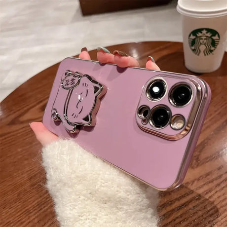 A person holding a pink phone case with a cat on it