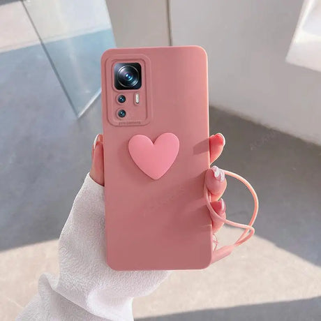 A person holding a pink phone case with a heart on it