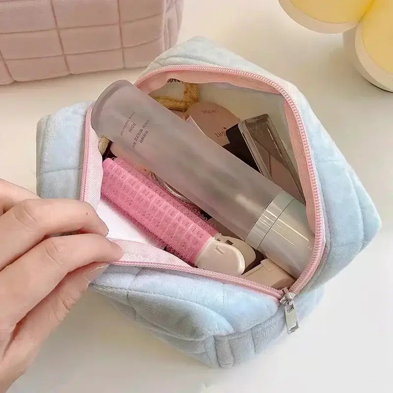 a person putting a pink tooth brush in a blue bag