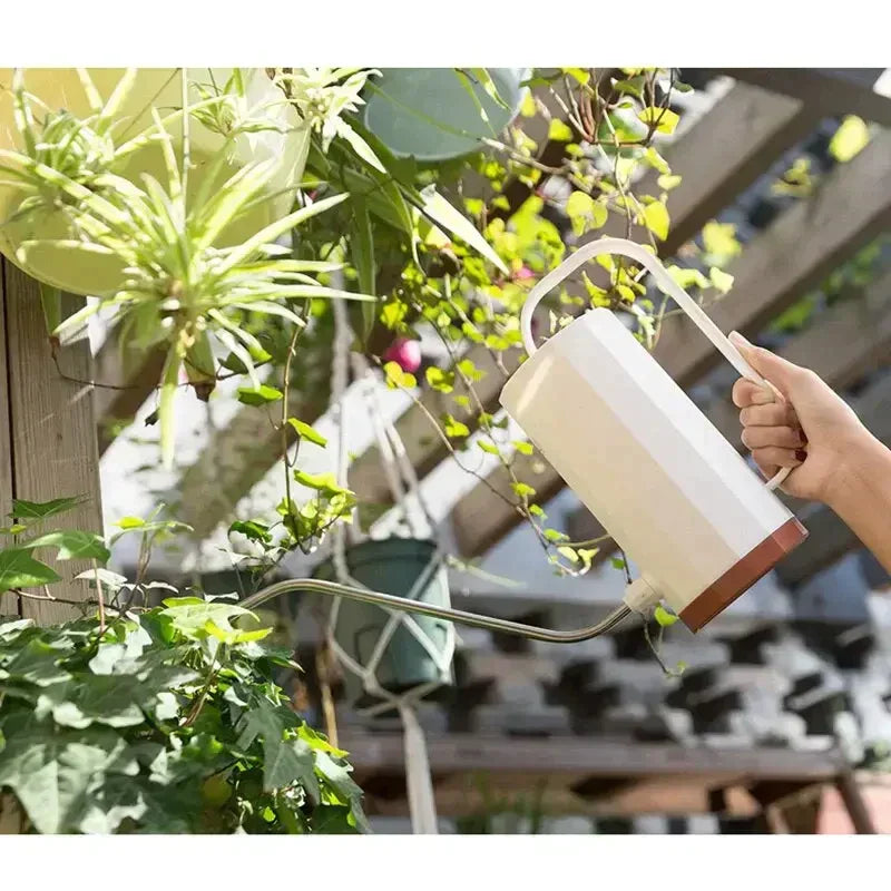 a person watering plants with a watering hose