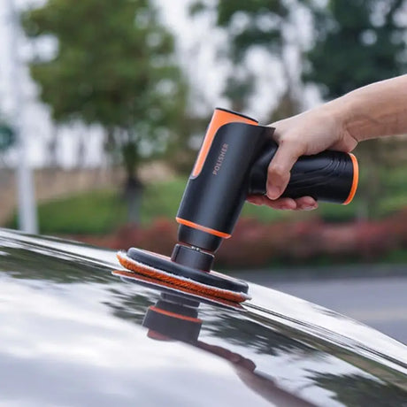 a person polishing a car with a polisher