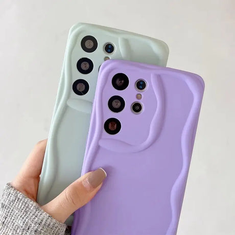 A person holding a purple and green iphone case