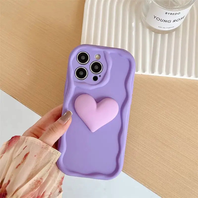 a person holding a purple phone case with a heart