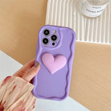 a person holding a purple phone case with a heart