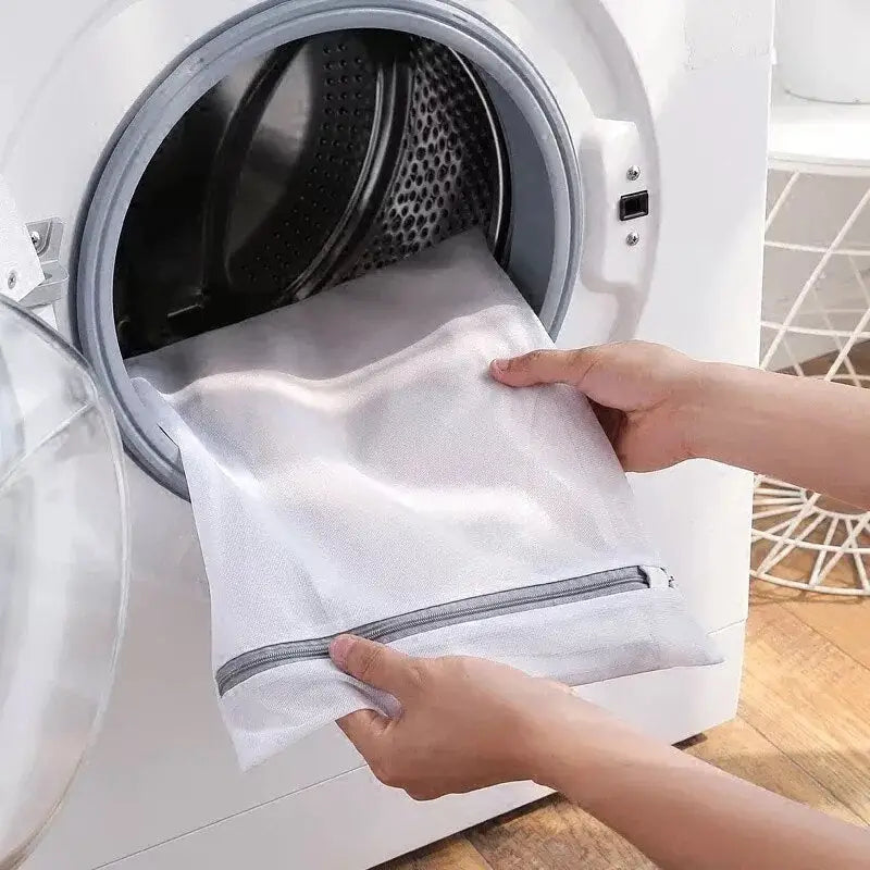 a person putting a towel into a washing machine