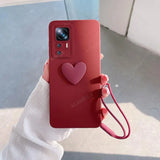a person holding a red phone case with a heart on it