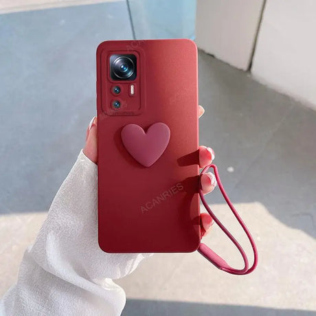 A person holding a red phone case with a heart on it