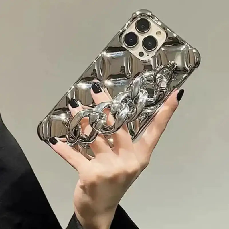 a person holding a silver phone case