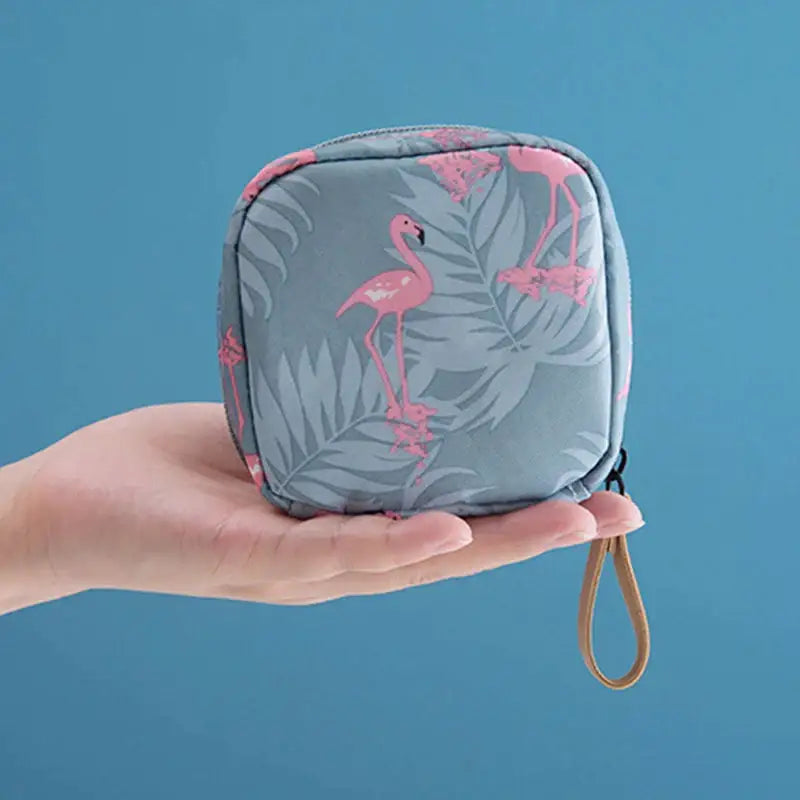 a person holding a small pink flamings print cosmetic bag