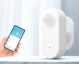 A person holding a smart phone and a smart home security device