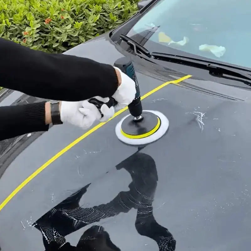 a person using a sponge to clean the windshield