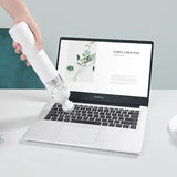 A person using a spray bottle to spray a laptop